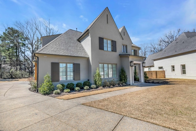 view of front of house featuring stucco siding and roof with shingles