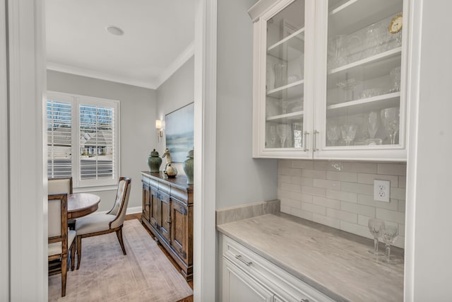 bar featuring baseboards, tasteful backsplash, and ornamental molding