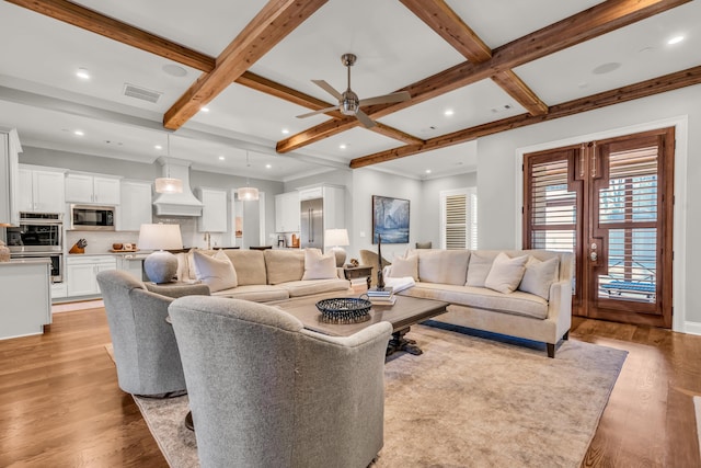 living room with beam ceiling, visible vents, light wood-style flooring, and coffered ceiling