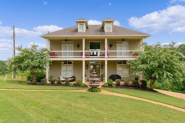 view of front of property with french doors, roof with shingles, a front yard, a balcony, and ceiling fan