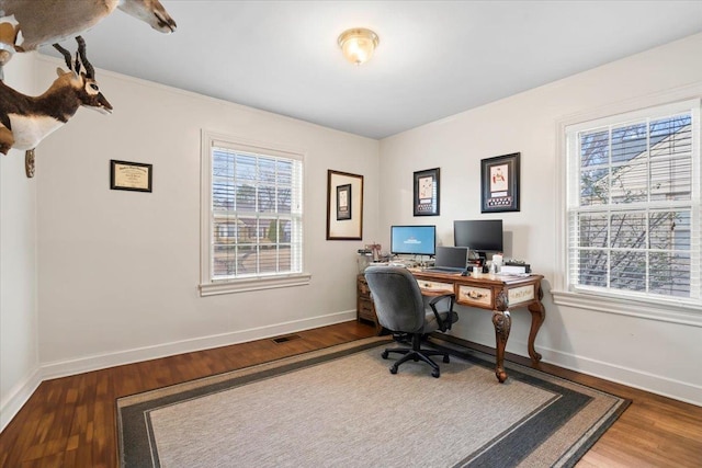 home office featuring visible vents, baseboards, and wood finished floors