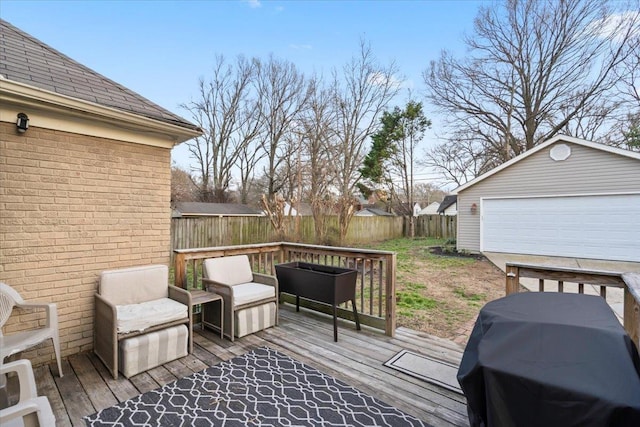 wooden terrace with an outbuilding, area for grilling, a detached garage, and fence