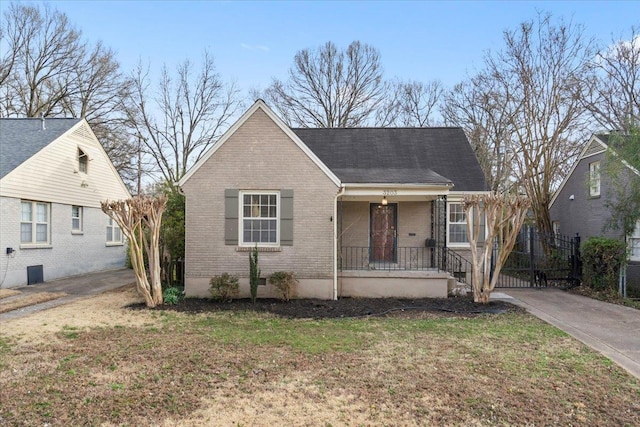 view of front of property featuring brick siding, a porch, and a front lawn