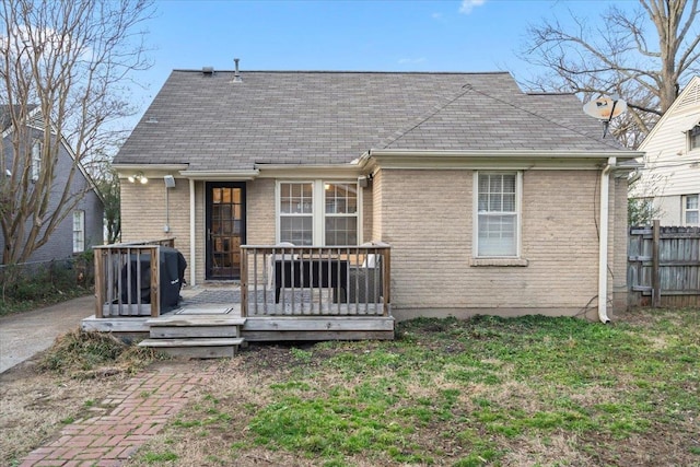 back of house featuring a deck, a yard, fence, and brick siding