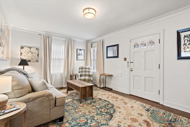 entryway featuring wood finished floors, baseboards, and ornamental molding