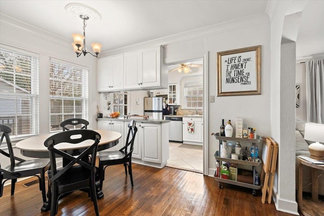 dining space featuring ceiling fan with notable chandelier, crown molding, and hardwood / wood-style flooring