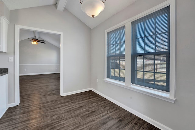 unfurnished dining area with a ceiling fan, lofted ceiling with beams, dark wood-style floors, and baseboards