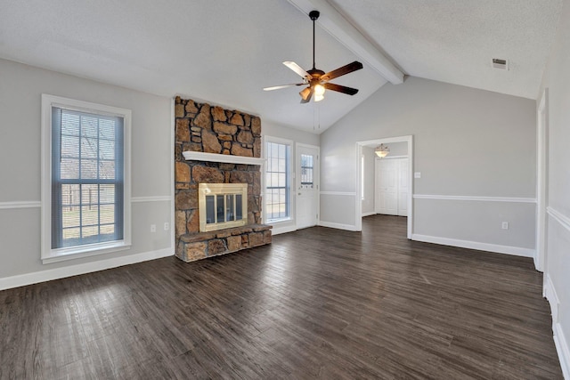 unfurnished living room featuring dark wood-style floors, plenty of natural light, a fireplace, and visible vents