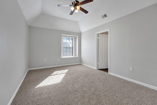 unfurnished bedroom featuring visible vents, lofted ceiling, a textured ceiling, carpet floors, and baseboards