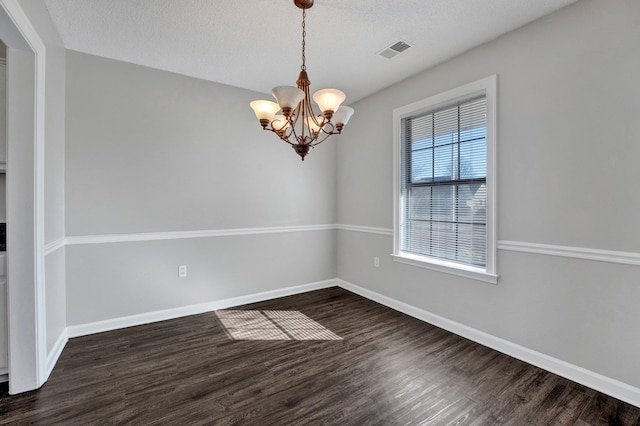 spare room featuring wood finished floors, visible vents, and baseboards