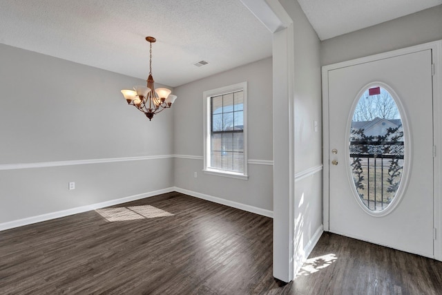 foyer with a chandelier, visible vents, dark wood-type flooring, and baseboards