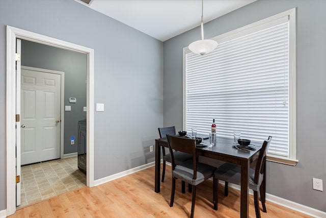 dining space with light wood-style flooring and baseboards