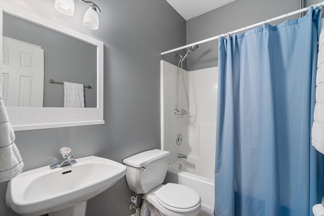 bathroom with shower / tub combo, toilet, and a sink