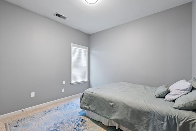 bedroom featuring visible vents, baseboards, and carpet