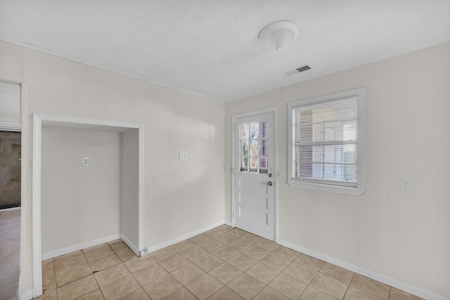 entryway with visible vents, baseboards, a textured ceiling, and light tile patterned flooring