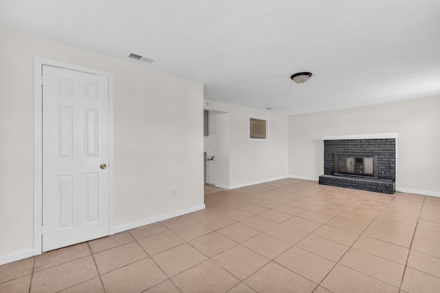 unfurnished living room with light tile patterned floors, visible vents, baseboards, and a fireplace