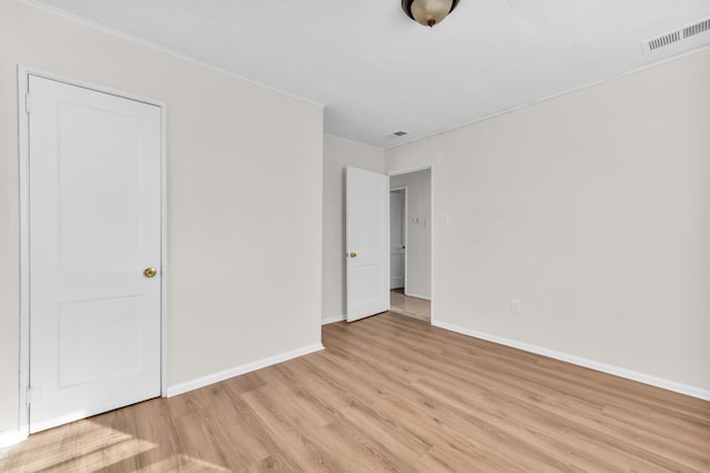 unfurnished bedroom featuring light wood-style flooring, baseboards, and visible vents