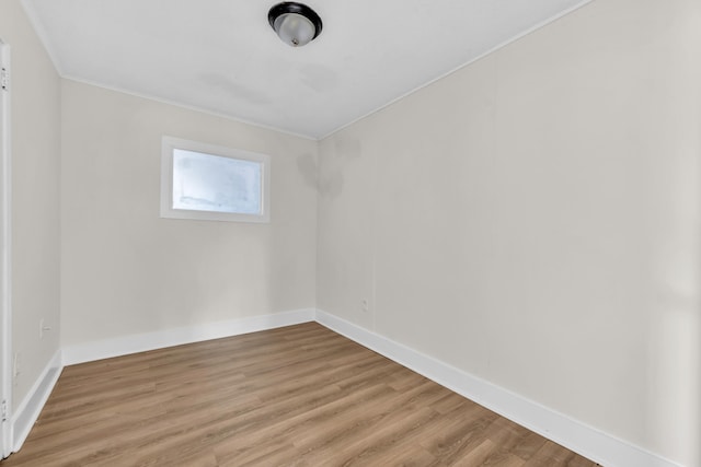 spare room featuring light wood-type flooring and baseboards