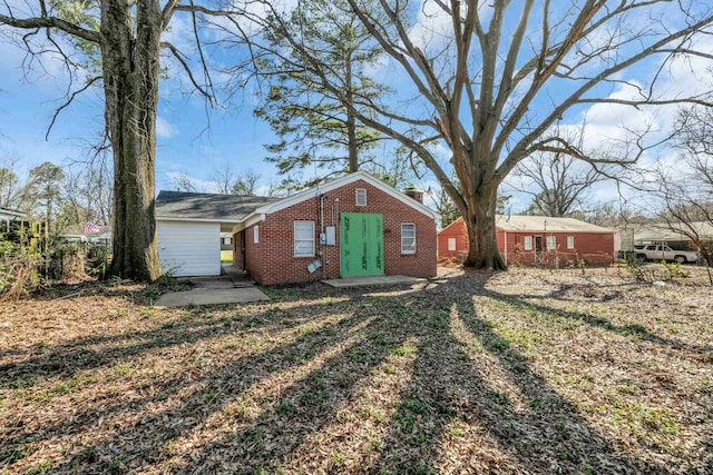 exterior space with brick siding and a chimney