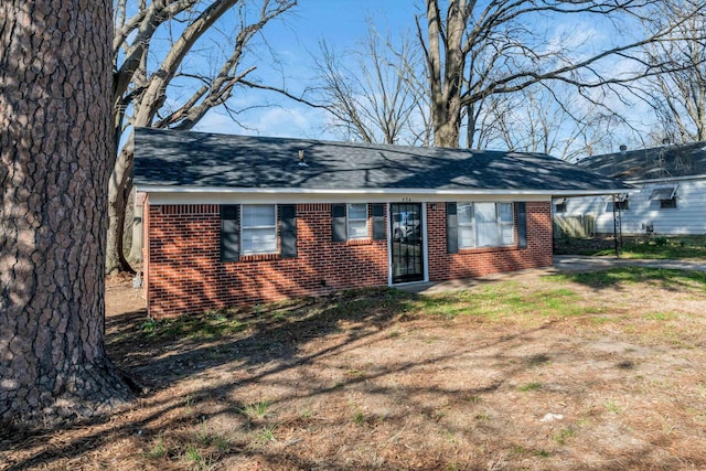 ranch-style home featuring brick siding and roof with shingles