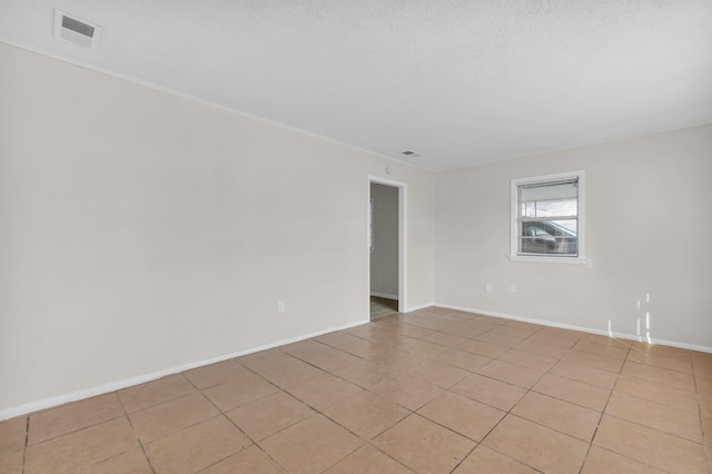 unfurnished room with visible vents, baseboards, a textured ceiling, and light tile patterned flooring