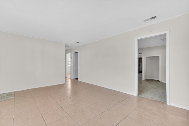 spare room with visible vents, baseboards, and ornamental molding