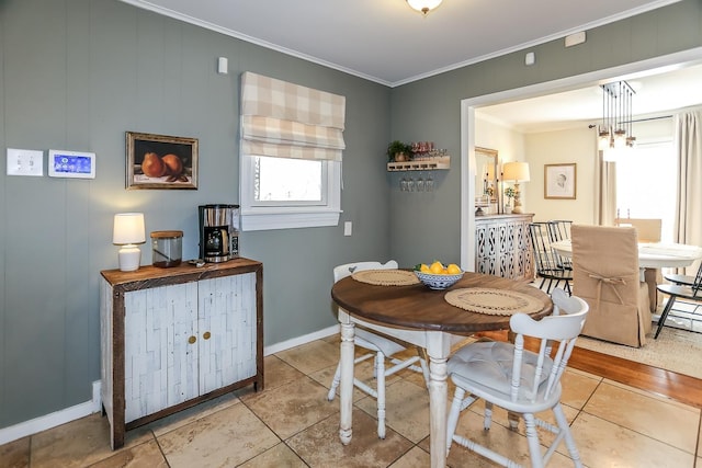 dining room featuring tile patterned flooring, crown molding, and baseboards