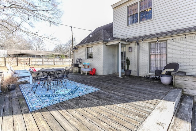 deck featuring outdoor dining space and fence