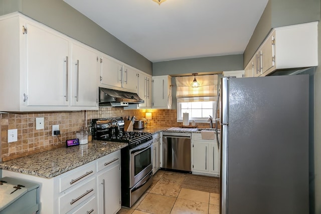 kitchen with tasteful backsplash, under cabinet range hood, stone counters, white cabinets, and stainless steel appliances