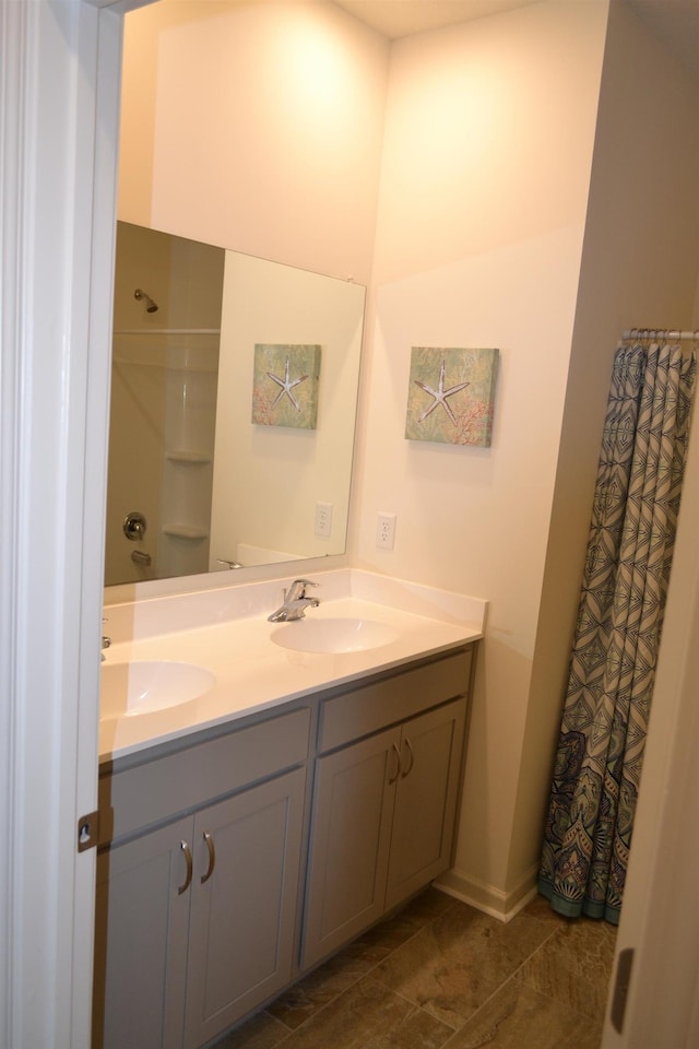 bathroom with a sink, curtained shower, and double vanity