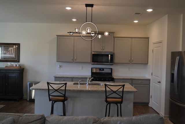 kitchen featuring visible vents, gray cabinets, appliances with stainless steel finishes, and a sink