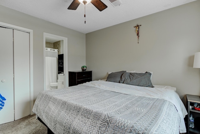 bedroom featuring visible vents, ceiling fan, carpet floors, a textured ceiling, and ensuite bath