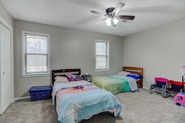 carpeted bedroom featuring baseboards, a closet, and a textured ceiling