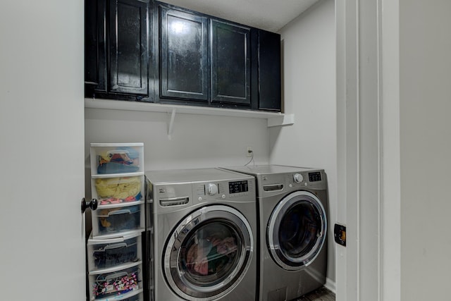 washroom featuring washing machine and dryer and cabinet space