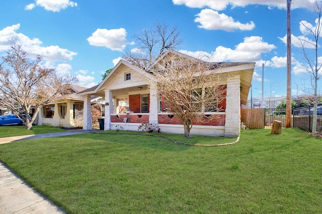 view of front of house with covered porch, a front lawn, and fence