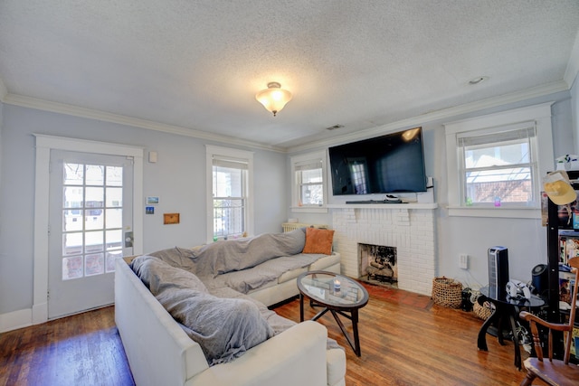 living room with plenty of natural light, wood finished floors, and ornamental molding