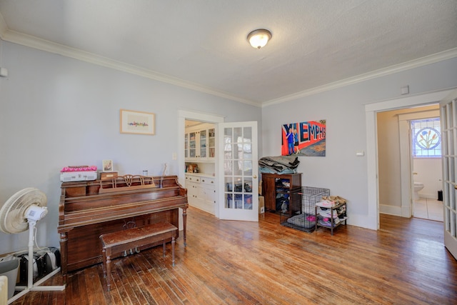 living area with ornamental molding, french doors, baseboards, and hardwood / wood-style floors