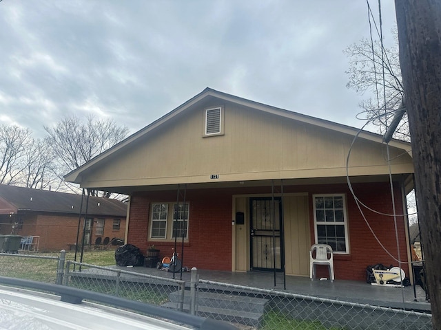 view of front of property with a porch, fence, and brick siding