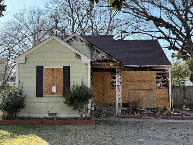 view of front of house featuring crawl space, fence, and a shingled roof