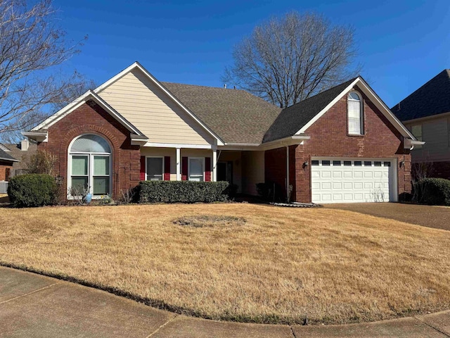 view of front facade with brick siding, a garage, and a front yard