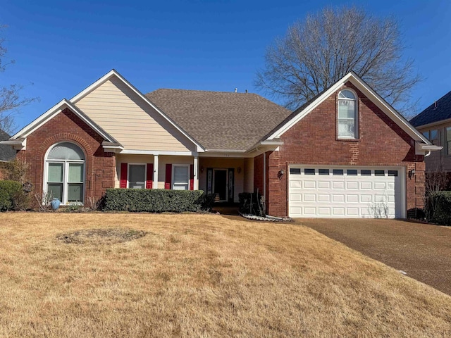 view of front of home featuring driveway, brick siding, a front yard, and a shingled roof