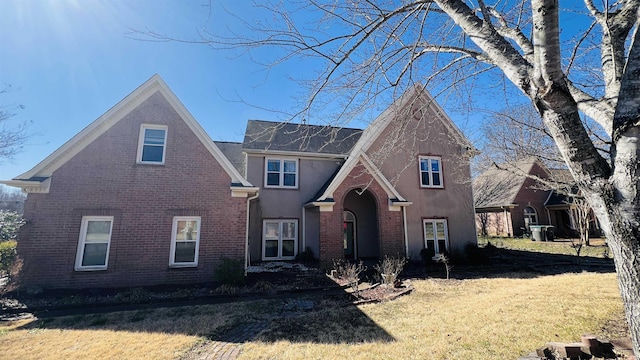 traditional-style house with brick siding and a front yard