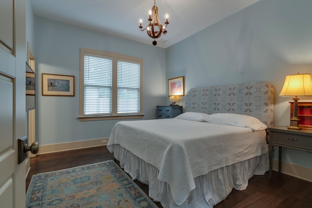 bedroom with baseboards, an inviting chandelier, and wood finished floors