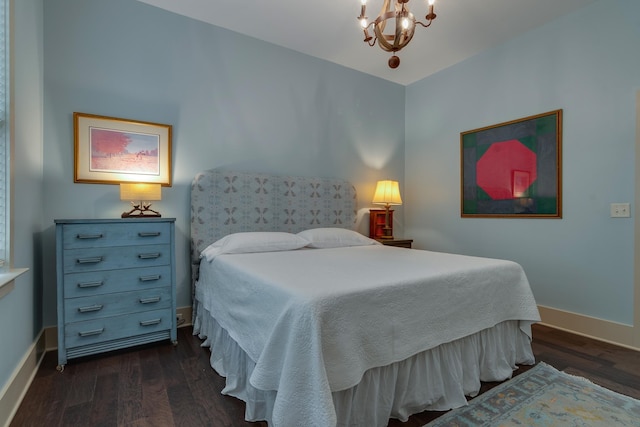 bedroom featuring dark wood-type flooring, baseboards, and a chandelier