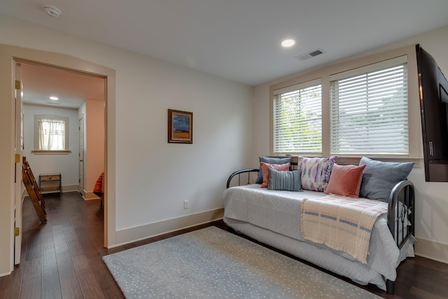 bedroom featuring visible vents, multiple windows, and dark wood-style flooring