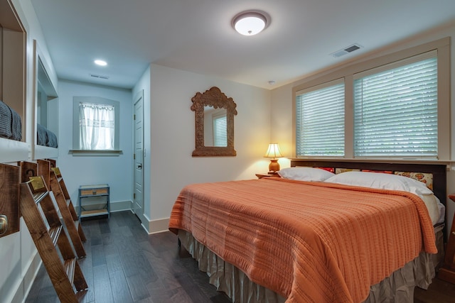 bedroom with visible vents, baseboards, and wood finished floors