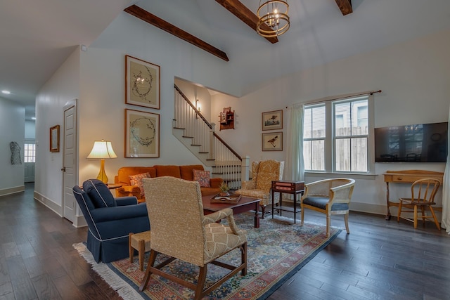 living area with beam ceiling, a notable chandelier, wood finished floors, baseboards, and stairs