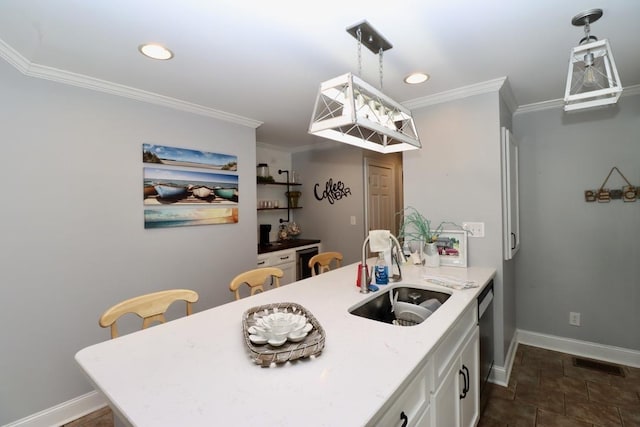 kitchen featuring visible vents, a sink, white cabinetry, crown molding, and baseboards