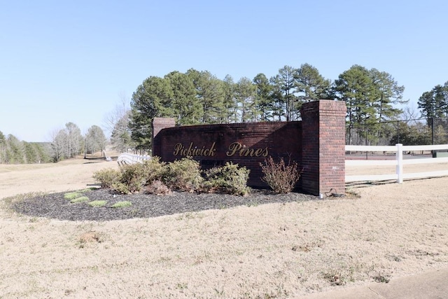 community / neighborhood sign featuring fence