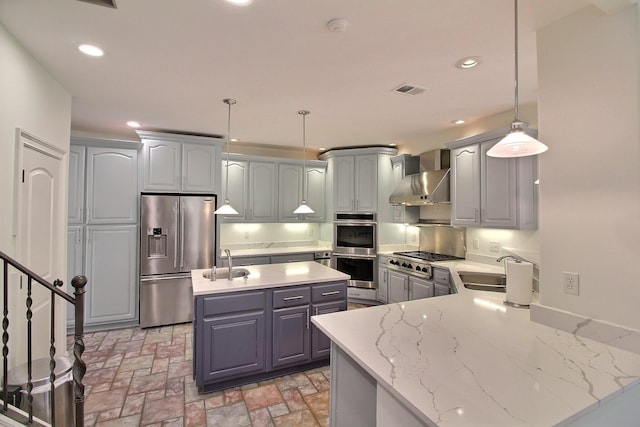 kitchen featuring a sink, stainless steel appliances, recessed lighting, and wall chimney range hood